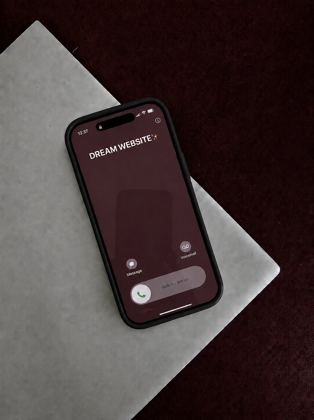 A phone showing an incoming call from Dream Website, starting a Denver web design project