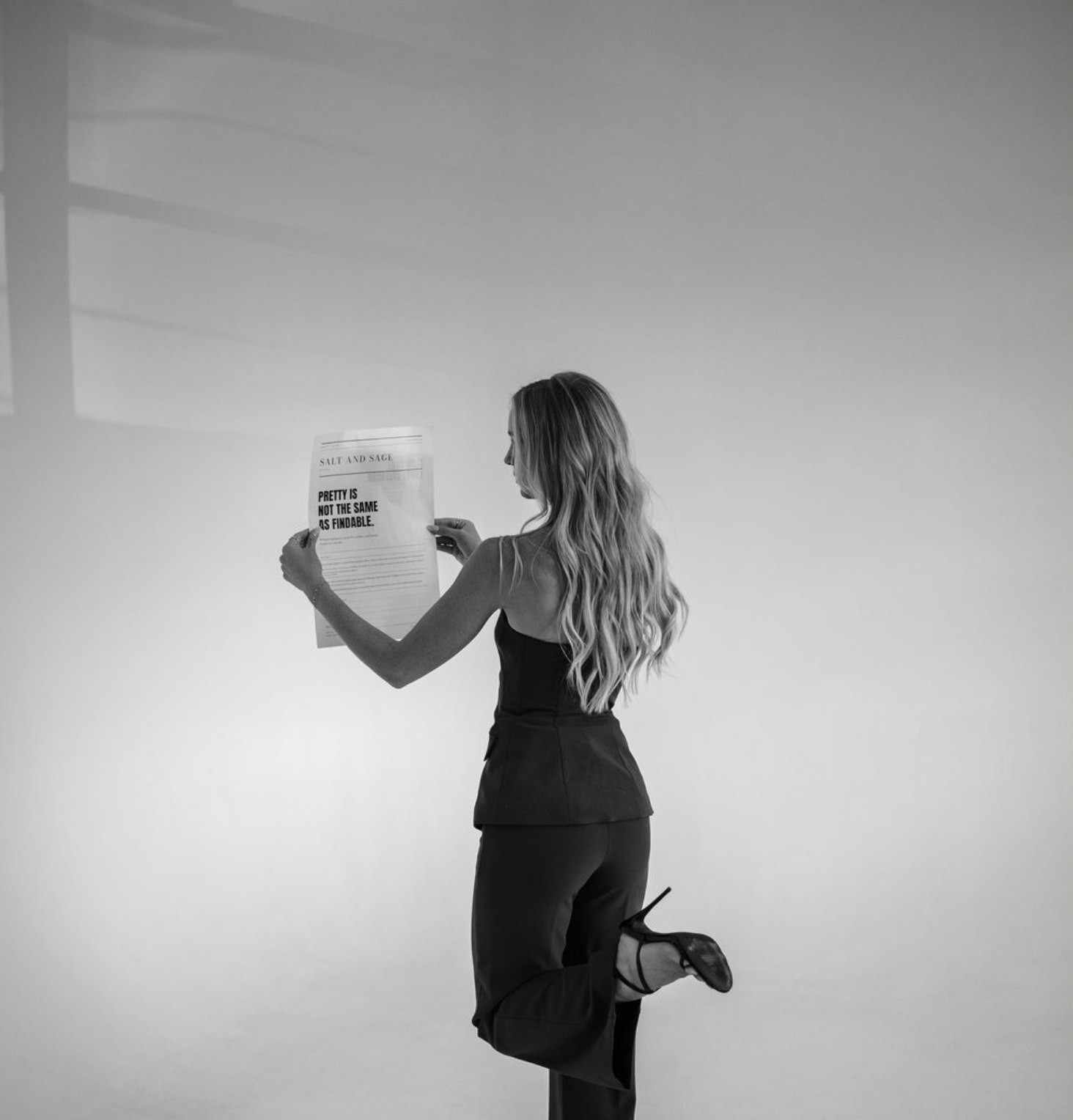 Sabrina studying the Salt and Sage newspaper, how a website reads before a client ever sees it