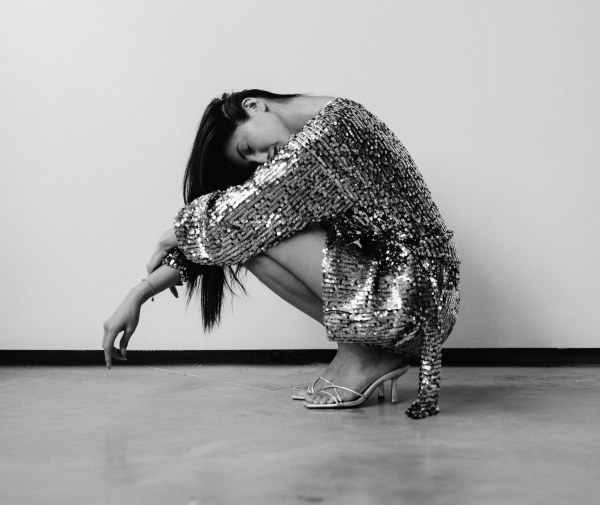 An editorial content moment in black and white: sequins against a bare studio wall